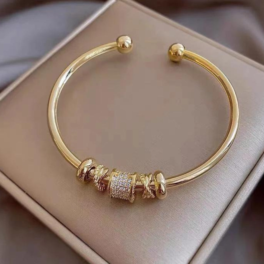 Glänzendes Armreif mit Zirkonia-besetztem Zylinder und eleganten Ringen