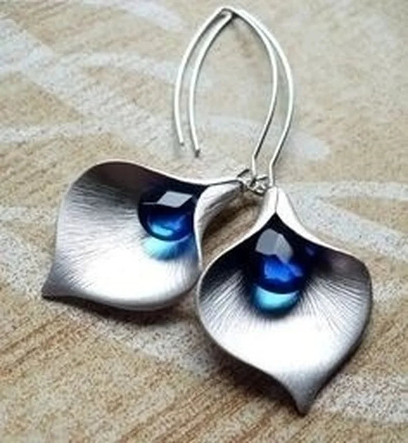 Elegante Blütenohrringe mit funkelndem blauen Tropfen-Stein