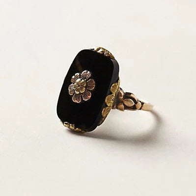 Vintage-Ring mit schwarzem Stein und floralen Details in Gold
