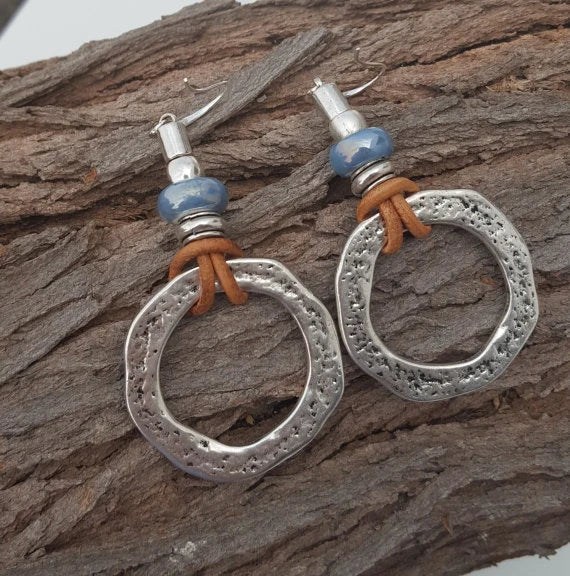 Handgefertigte Ohrringe mit blauen Glasperlen und Lederdetails