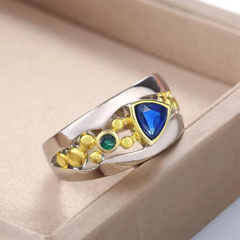 Zeitloser Ring aus Bicolor-Metall mit blauem Edelstein und Goldakzenten