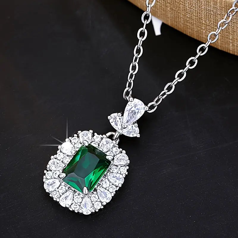 Eleganter Smaragd-Anhänger mit Zirkonia-Halo an filigraner Kette