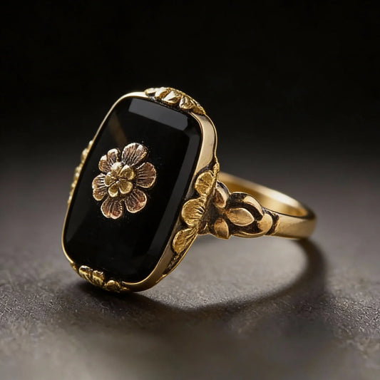 Vintage-Ring mit schwarzem Stein und floralen Details in Gold