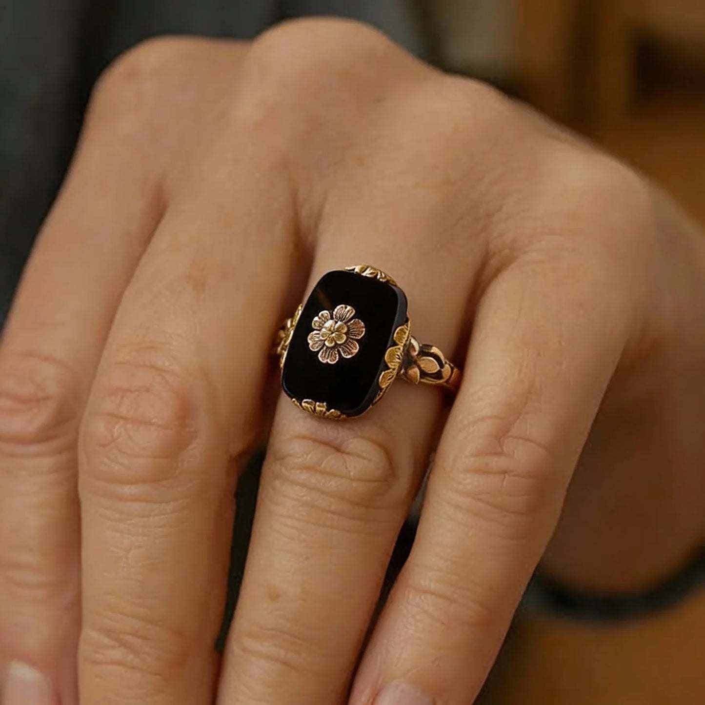 Vintage-Ring mit schwarzem Stein und floralen Details in Gold