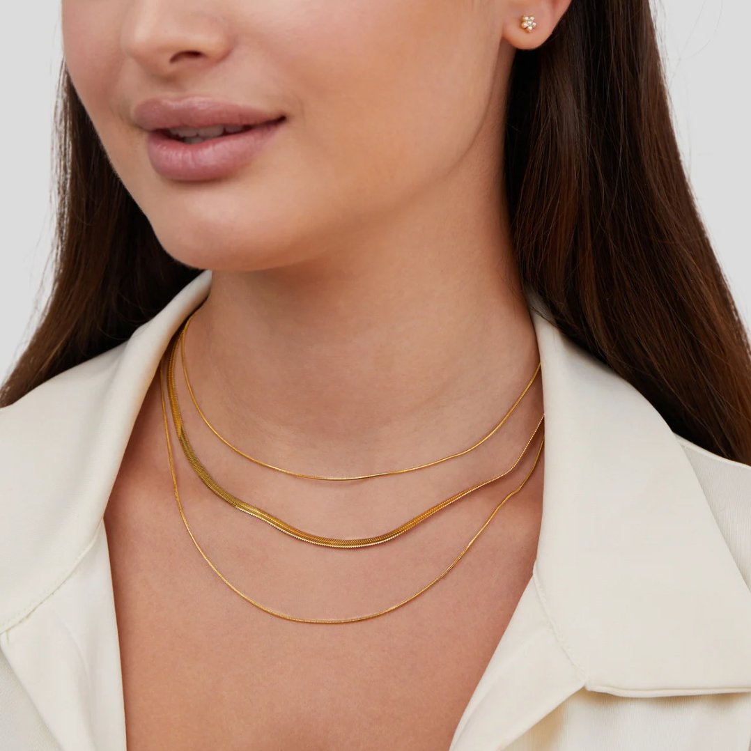 Zeitloses Layering aus glatten, geschmeidigen Schlangenketten für elegante Looks