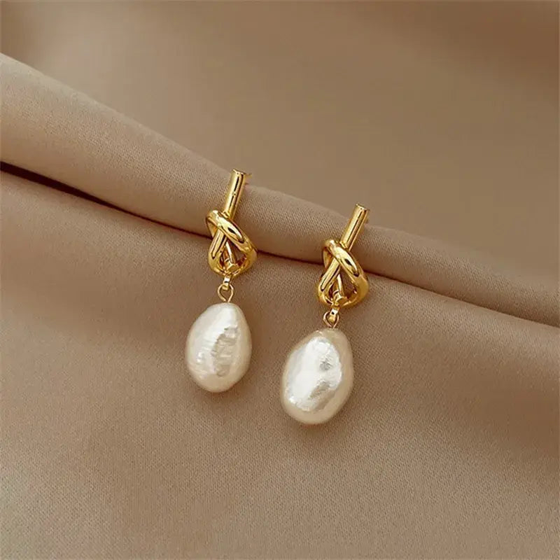 Elegante Ohrringe mit stilvollem Knoten und weißen Süßwasserperlen