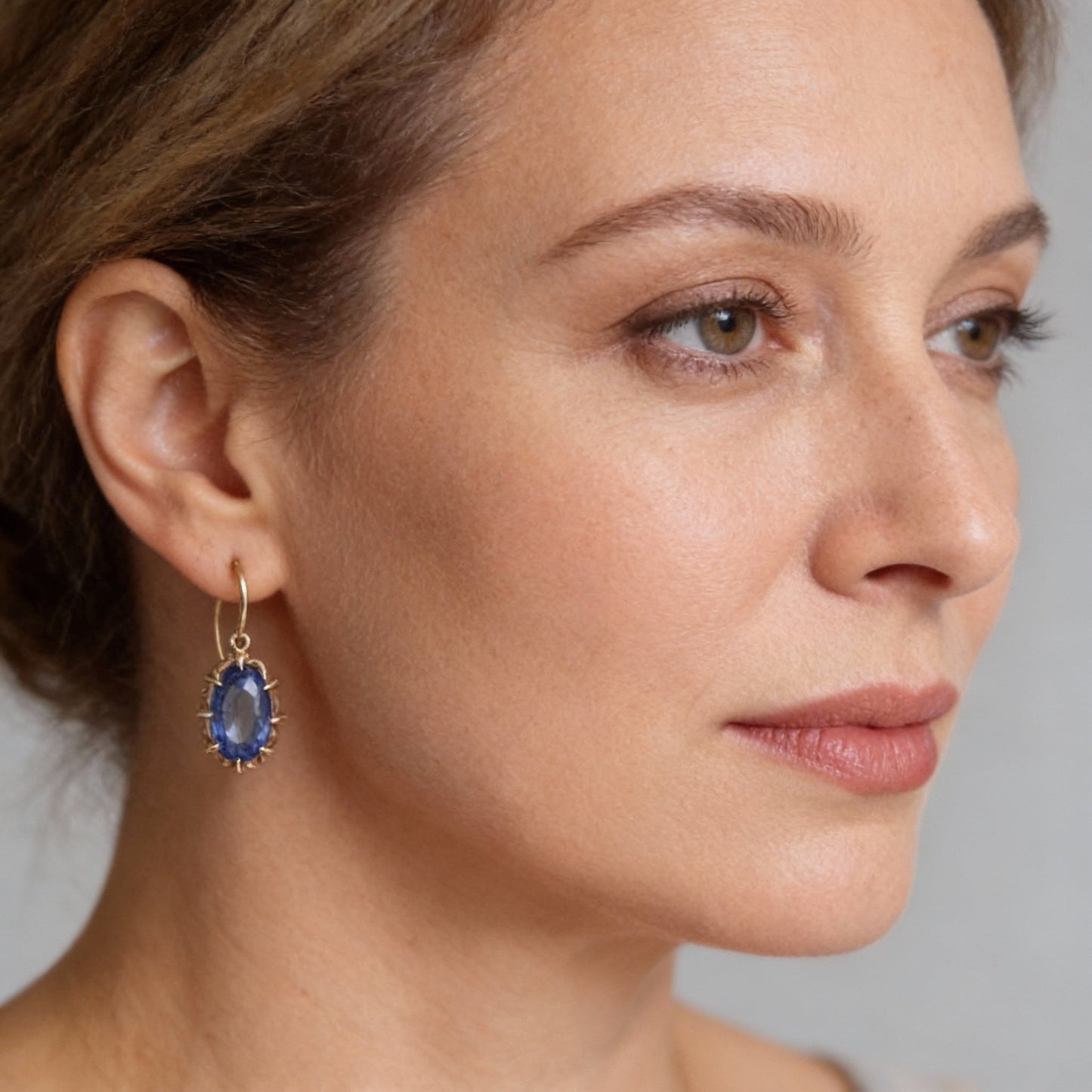 Elegante Hakenohrringe mit ovalem, facettiertem blauem Edelstein